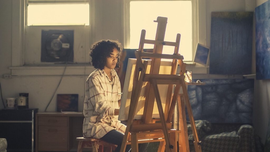 Leila is painting in her small studio and thinking about her SMART social media goals