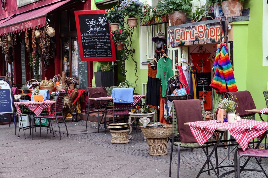 A colorful sidewalk in Berlin with a cafe and a clothing shop